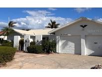 White single-story home with a two-car garage and well-maintained landscaping at 2000 Kansas Ne Ave, St Petersburg, FL 33703