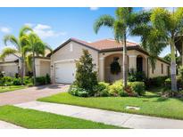 Single-story home with a tan exterior, white garage door, and landscaped front yard at 200 Soliera St, Nokomis, FL 34275