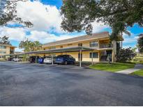 Charming condo building with covered parking in a well-maintained community with blue skies and mature trees at 12300 Vonn Rd # 9105, Largo, FL 33774