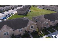 Aerial view of townhouses with parking and green space at 27536 Desert Willow Way, Wesley Chapel, FL 33544