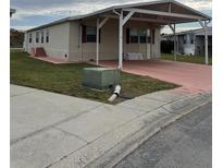 Mobile home with carport and landscaped lawn at 8343 Fantasia Park Way, Riverview, FL 33578