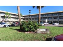 Building exterior, featuring landscaped grounds and parking at 2462 Brazilia Dr # 20, Clearwater, FL 33763