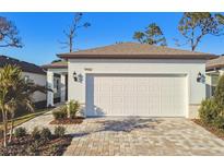 White garage door and paved driveway of a new home at 9442 Shorebird Ct, Parrish, FL 34219