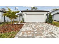 White house exterior with a two-car garage and landscaped front yard at 9446 Shorebird Ct, Parrish, FL 34219