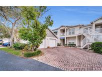 Two-story condo building with attached garage and brick driveway at 14880 Shipwatch Trce # 1915, Largo, FL 33774