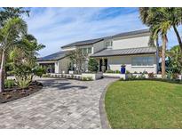 Stunning waterfront home with a metal roof, paver driveway, and lush landscaping at 4931 61St S Ave, St Petersburg, FL 33715