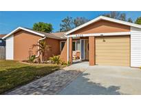 Charming one-story home featuring an attached garage, manicured lawn, and welcoming front entrance at 5705 103Rd N Ter, Pinellas Park, FL 33782