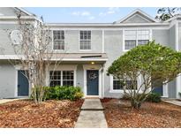 Gray townhome with landscaping, walkway, and a blue front door at 2345 Lake Woodberry Cir, Brandon, FL 33510