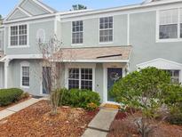 Attractive townhome exterior, featuring a light gray facade, landscaping, and a welcoming front entrance at 2345 Lake Woodberry Cir, Brandon, FL 33510