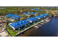Beautiful waterfront condo complex featuring private boat docks, manicured lawns, and vibrant blue roofs at 1688 Watermark Ne Cir # 1688, St Petersburg, FL 33702