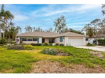 Ranch-style home with attached garage and mature landscaping at 5257 Venetian Ne Blvd, St Petersburg, FL 33703
