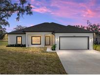 One-story home with attached garage, neutral color palette, and landscaping at 5364 Boxtree Ct, Dade City, FL 33523