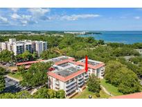 Stunning aerial view of a condo complex surrounded by lush trees with waterfront views and community landscaping at 2650 Pearce Dr # 403, Clearwater, FL 33764
