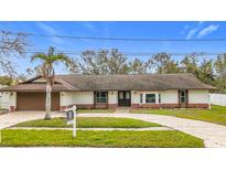 Newly renovated single-Gathering home with a brown garage door and landscaped yard at 1557 Jeffords St, Clearwater, FL 33756