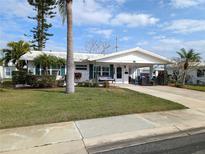 Charming single-story home featuring a well-manicured lawn and cozy covered porch area at 4415 96Th N Ave, Pinellas Park, FL 33782