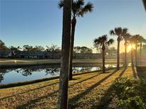 Sunrise view of tranquil community lake and lush landscaping at 4452 Weybridge St # 74, Sarasota, FL 34235