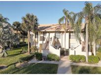 Attractive condo building with lush landscaping and palm trees at 4452 Weybridge St # 74, Sarasota, FL 34235