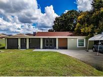 House exterior featuring a green house with a red roof and spacious lawn at 11224 Inglewood Dr, Gibsonton, FL 33534