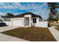 Newly constructed home with modern facade, driveway, and landscaped lawn at 2513 W Hiawatha St, Tampa, FL 33614