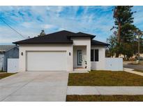 Modern house with white exterior, black roof, and a two-car garage at 2513 W Hiawatha St, Tampa, FL 33614