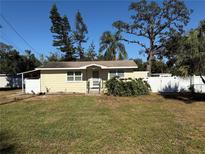 Cute yellow house with a large yard and white fence at 1810 E Poinsettia Ave, Tampa, FL 33612