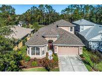 Charming single-Gathering home with a well-manicured front yard and attached two car garage at 7815 Blue Spring Dr, Land O Lakes, FL 34637