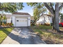 Front view of charming condo with attached garage and well-maintained landscaping at 155 Nina Way, Oldsmar, FL 34677