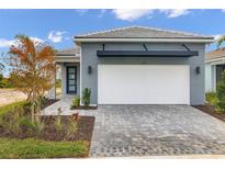 New construction home with gray exterior, white garage door and landscaping at 11211 Livewell Ct, Venice, FL 34293