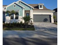 Two-story home with gray garage and landscaped yard at 1578 Running Tide Pl, Sarasota, FL 34240