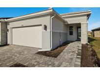 House exterior featuring a two-car garage and a walkway at 11267 Boundless Ter, Venice, FL 34293