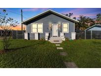 Newly renovated home with gray siding, landscaped lawn, and walkway at 702 E Gilchrist St, Plant City, FL 33563