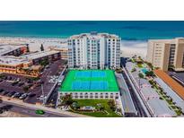 Aerial view of beachfront condo building with tennis courts and ocean views at 4950 Gulf Blvd # 206, St Pete Beach, FL 33706