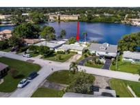 Aerial view of waterfront home with private dock and lush landscaping at 8800 Sunlit Cove Ne Dr, St Petersburg, FL 33702