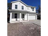 Two-story farmhouse style home with white siding and gray garage door at 709 W Orient St, Tampa, FL 33603