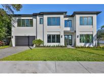Stunning modern two-story home featuring a minimalist aesthetic, sleek lines, and manicured landscaping at 4608 S Ferdinand Ave, Tampa, FL 33611