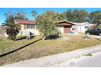 Charming single-story home featuring a front yard with mature landscaping and a covered entrance at 7521 Coventry Dr, Port Richey, FL 34668