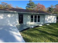 Newly renovated house featuring a fresh coat of paint and a well-manicured lawn at 833 Leeward Way, Palm Harbor, FL 34685