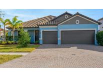 Two-car garage and light blue exterior at 11926 Cinnamon Fern Dr, Riverview, FL 33579
