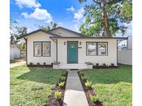 Charming bungalow with teal front door, landscaping, and walkway at 1227 E Mohawk Ave, Tampa, FL 33604