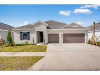 Charming single-story home with a well-manicured lawn, two-car garage, and neutral color palette at 2311 Overfalls Pl, Wesley Chapel, FL 33543