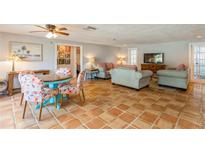 Bright living room with terracotta tile floors, comfortable sofas, and a flat-screen TV at 9830 Mark Twain Ln, Port Richey, FL 34668