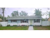 Updated bungalow with light blue and white exterior, landscaped lawn, and a walkway at 920 Hull S St, Gulfport, FL 33707