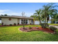 Ranch-style home with landscaped yard and attached garage at 2404 Forecastle Dr, Palm Harbor, FL 34685