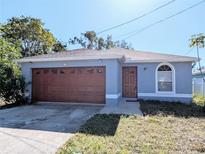 Newly constructed light blue home with a two-car garage and a well-manicured lawn at 2060 6Th St, Sarasota, FL 34237
