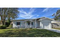 Charming house with newly landscaped lawn, attached garage, and light colored walls at 1722 St Croix Dr, Clearwater, FL 33759