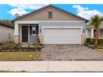 Craftsman style home with two-car garage and landscaped front yard at 3716 Maxwell Park Dr, Sun City Center, FL 33573