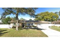 Tan single story home with attached garage and a spacious yard at 1948 Jeffords St, Clearwater, FL 33764