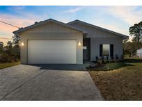 One-story home with white garage door and paved driveway at 6454 Freeport Dr, Spring Hill, FL 34608