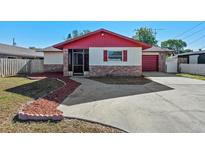 Charming single-Gathering home with red trim and a well-maintained front yard at 2233 Curlew Rd, Dunedin, FL 34698