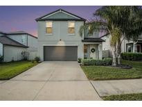 Two-story house with gray siding, two-car garage, and landscaped yard at 3873 Gainer Spring Avenue, New Port Richey, FL 34653